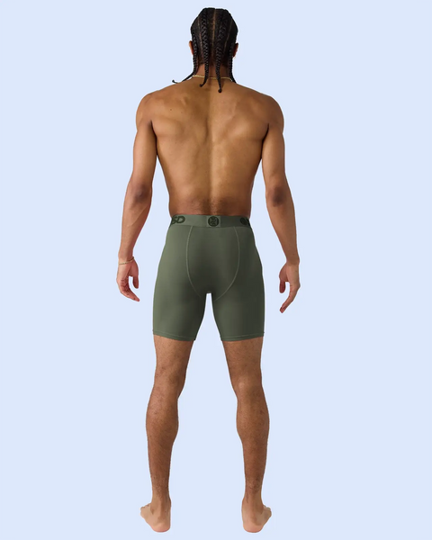 Man wearing forest green boxer briefs with elastic waistband, shown from back view.