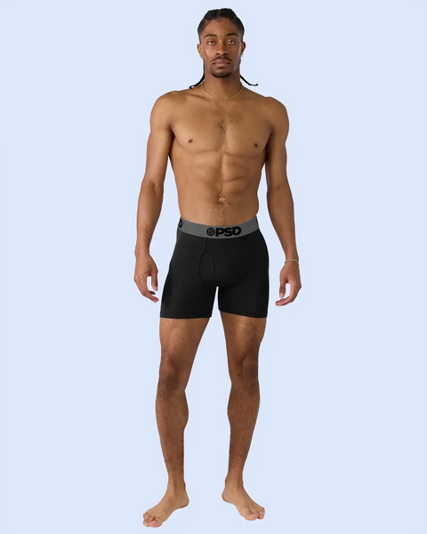Man wearing black boxer briefs with grey waistband.