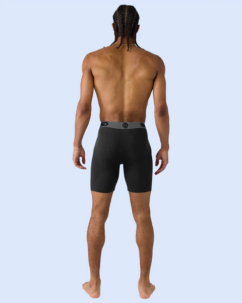 Man wearing black modal boxer briefs with grey waistband, shown from behind.